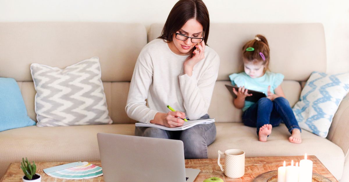 A working parent balancing a laptop on the kitchen counter while interacting with their child, illustrating the challenge of juggling work and parenting responsibilities